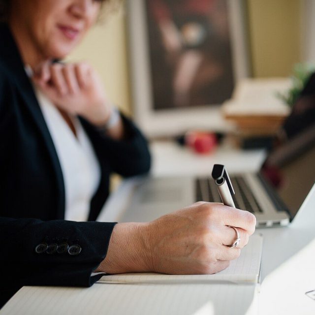 Professional taking notes during a one-to-one coaching session
