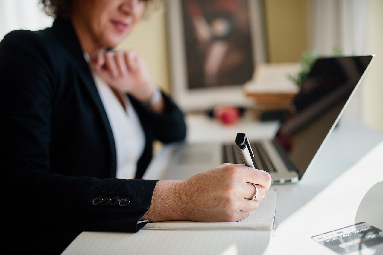 Professional taking notes during a one-to-one coaching session
